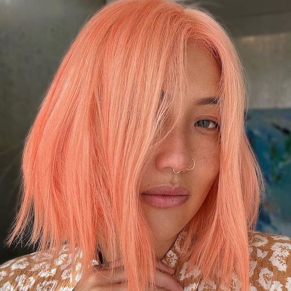 Model with a rosy-peach, blunt, chin-length bob, styled straight.