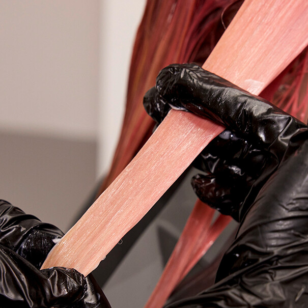 Close-up of SHINEFINITY Color Glaze being smoothed through the ends of blonde hair.