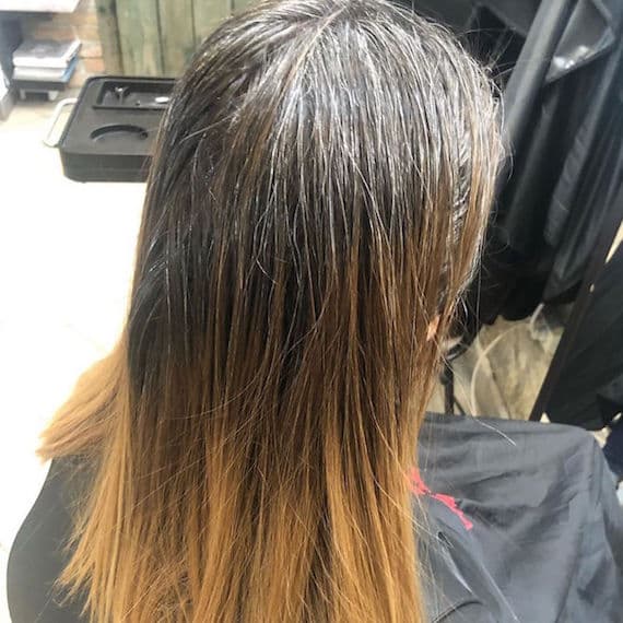 Hinterkopf einer Frau mit langem aschblondem Balayage, kreiert mit Wella Professionals.