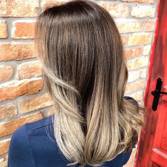 Hinterkopf einer Frau mit langem aschblondem Balayage, kreiert mit Wella Professionals.