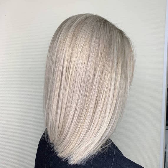 Side profile of woman with straight, ice blonde bob, created using Wella Professionals.