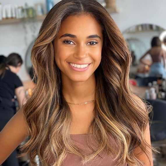 Model with long, wavy, caramel blonde and brown hair.