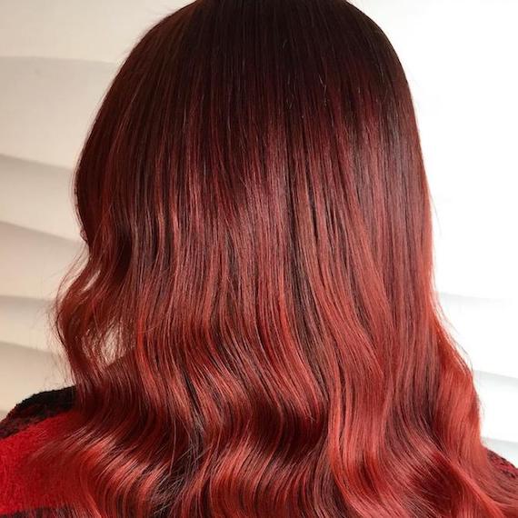 Photo of the back of a woman’s head with red hair, glossed using Wella Professionals