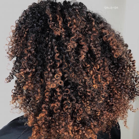 Photo of woman with dark brown, curly hair, created using Wella Professionals.