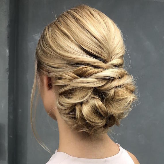 Photo of woman with blonde hair styled in a low chignon, created using Wella Professionals.