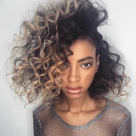 Woman with brunette and caramel split hair color through curl, created using Wella Professionals.