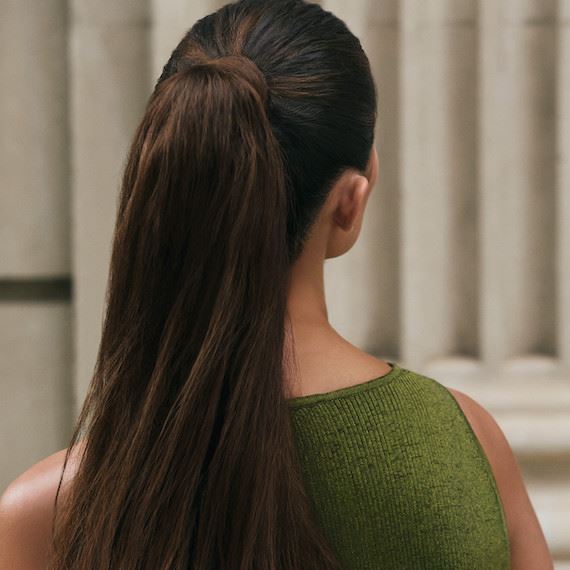 Hinterkopf eines Modells mit langen, braunen Haaren, die zu einem Pferdeschwanz gebunden sind.