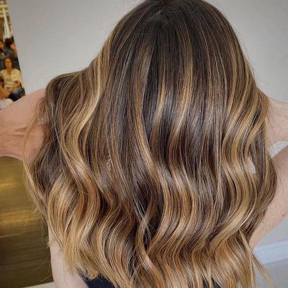 Frau mit honigblondem Twilighting, kreiert mit Wella Professionals.