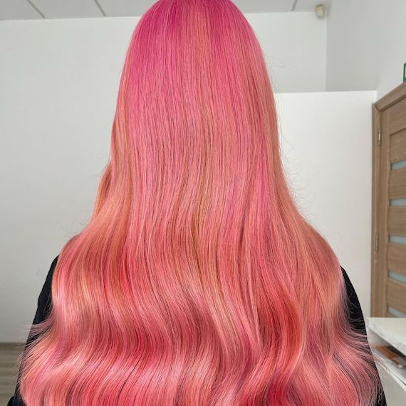 Model with long hot pink and neon peach hair.