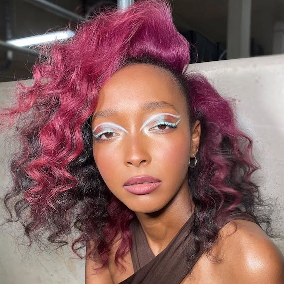 Model with dark brown hair featuring hot pink-purple highlights through the front.