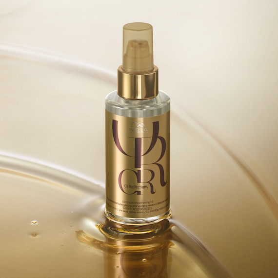 A bottle of Oil Reflections Luminous Smoothing Oil on a gold background.
