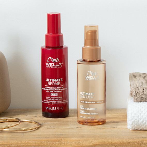 ULTIMATE REPAIR Miracle Hair Rescue and ULTIMATE SMOOTH Miracle Oil Serum on wooden surface.