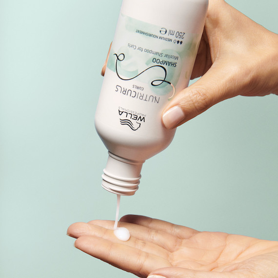 NutriCurls Shampoo is poured into hand.