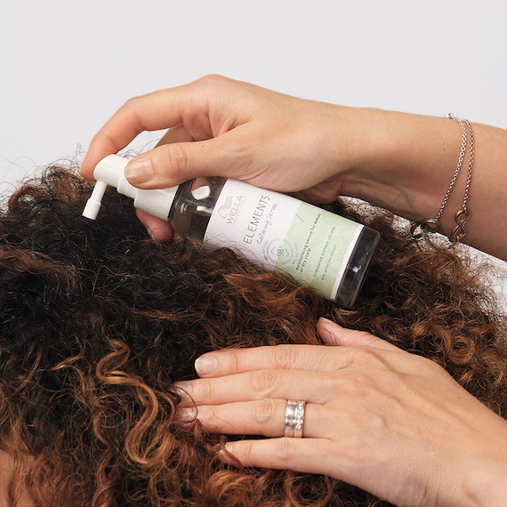 Elements Calming Serum is applied to model’s scalp.