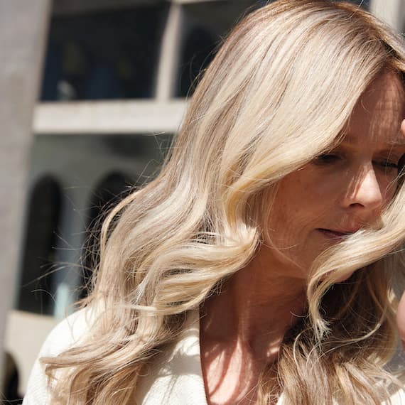 Nahaufnahme von gewelltem, creme-blondem Haar, kreiert mit Wella Professionals.
