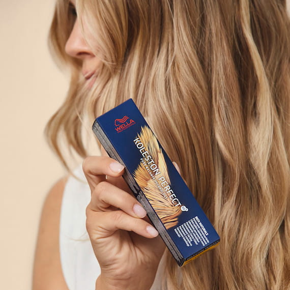 Nahaufnahme von blondem Haar, Frau hält Koleston Perfect Farbe.