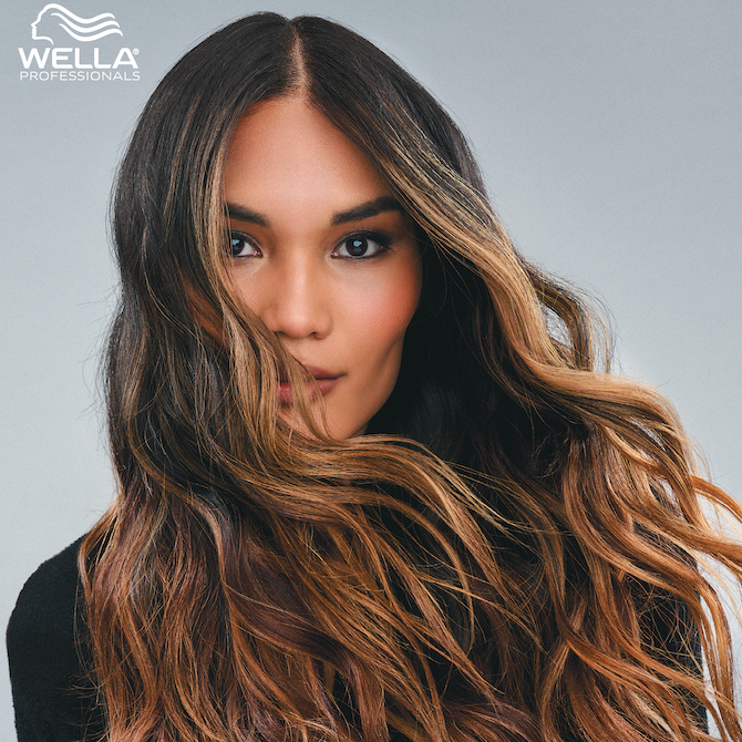 Model with long, wavy, dark hair and caramel balayage.