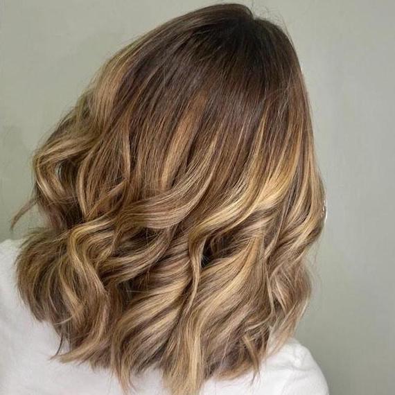 Hinterkopf einer Frau mit braunblondem Haar und Balayage, kreiert mit Wella Professionals.