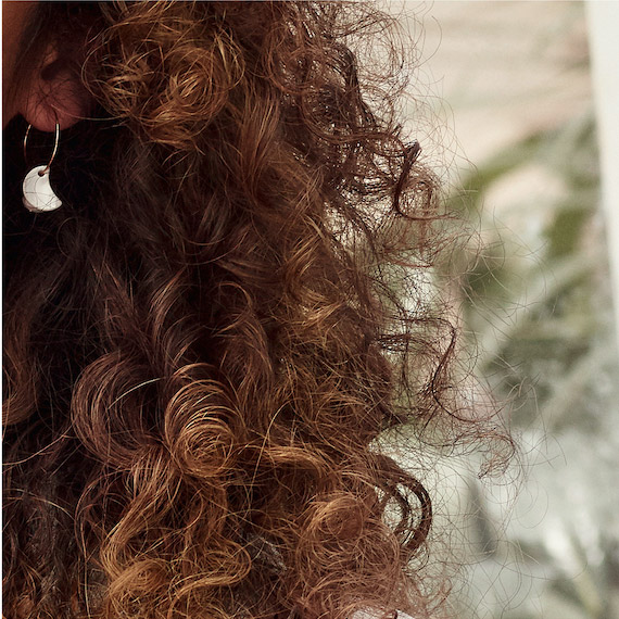 Close-up of model’s dark brown, curly hair.