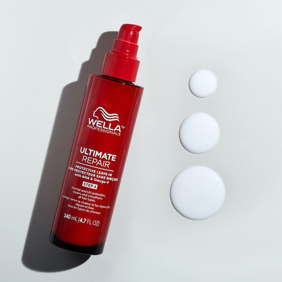 ULTIMATE REPAIR Protective Leave-In bottle next to drops of the heat protectant cream.