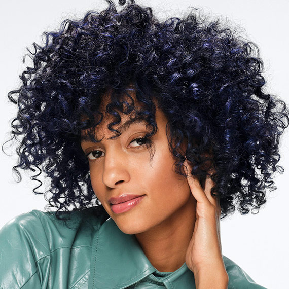Model with dark blue, curly hair.