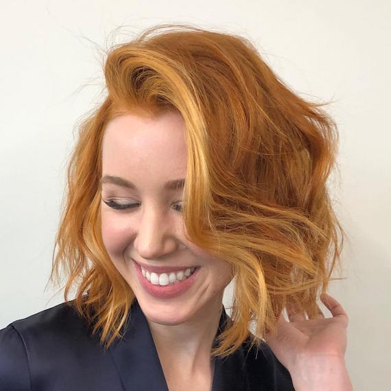 Woman with red bob hairstyle and partial balayage, created using Wella Professionals.