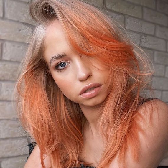 Model with light blonde hair featuring peach tones through the mid-lengths and ends.