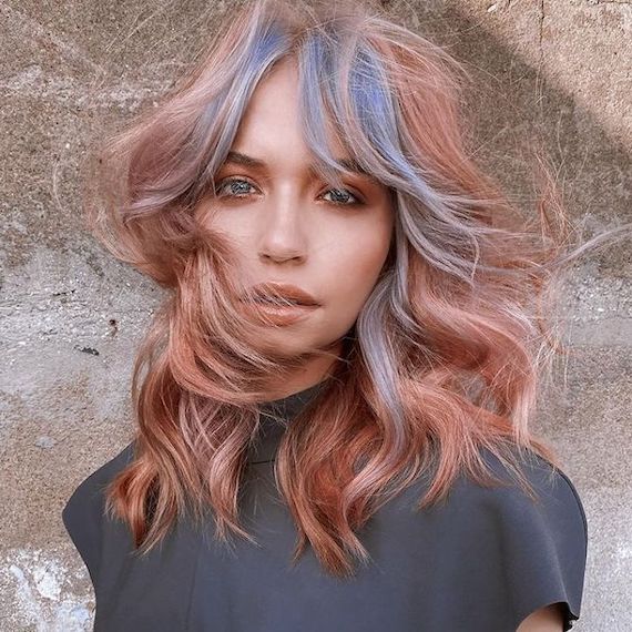 Model with shag haircut, featuring dusty rose lengths and blue bangs.