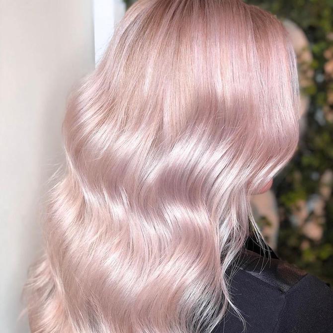 Hinterkopf einer Frau mit langem, gewelltem, rosa Platinhaar, kreiert mit Wella Professionals.
