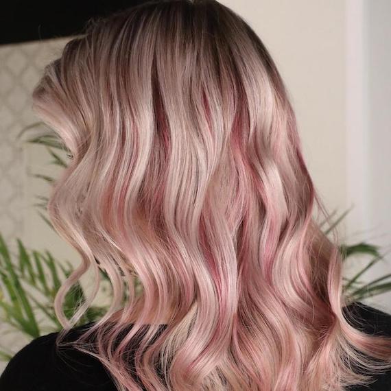 Hinterkopf einer Frau mit rosablondem Haar und dunklem Ansatz, kreiert mit Wella Professionals.