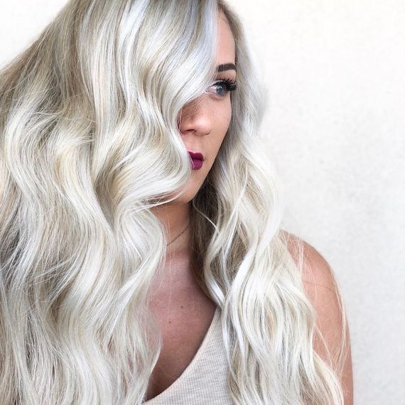 Model with beachy platinum blonde waves gazes to the side.