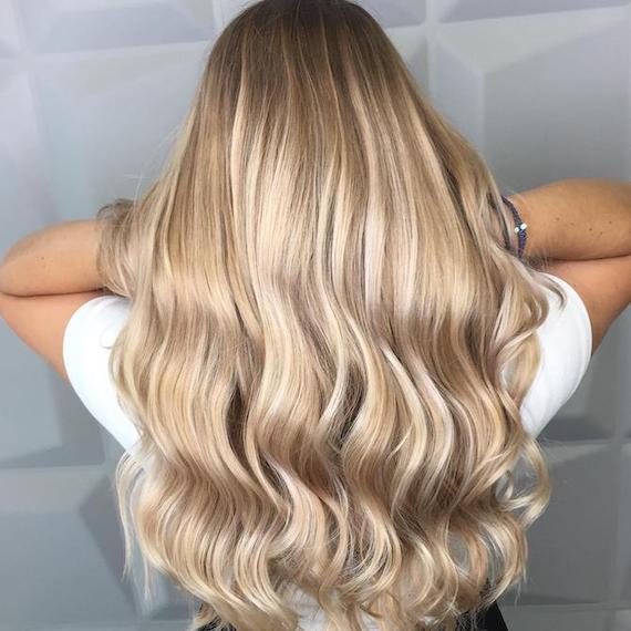 Photo of the back of a woman’s head with long hair and sandy blonde balayage, created using Wella Professionals. Photo of the back of a woman’s head with long hair and sandy blonde balayage, created using Wella Professionals.
