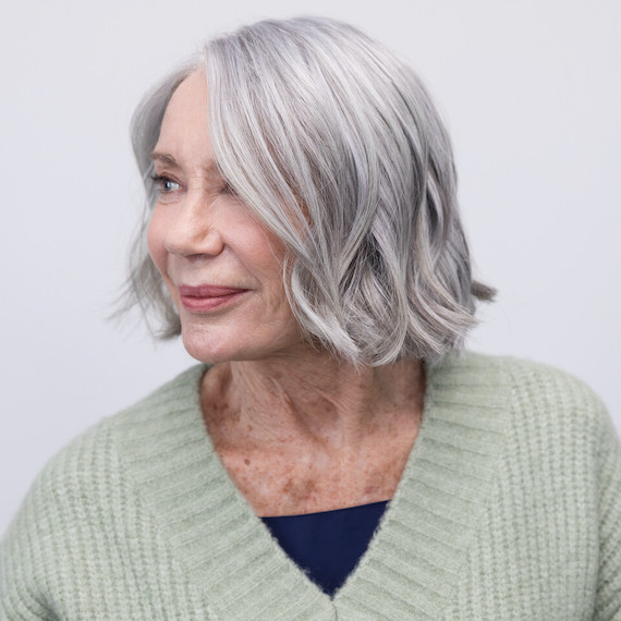 Woman with short, grey bob haircut hair looks off to the side.