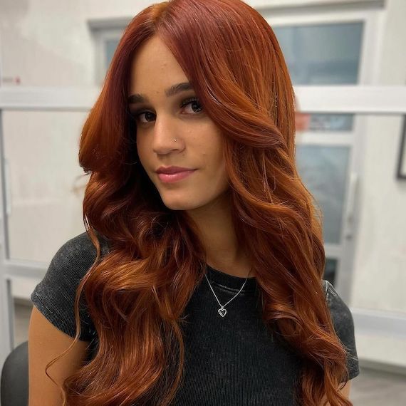 Model with long, loosely curled, auburn red hair.