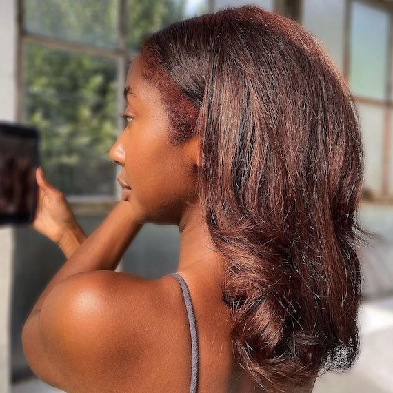 Back of model’s head showing their long, dark, glossy hair with cherry cola highlights.