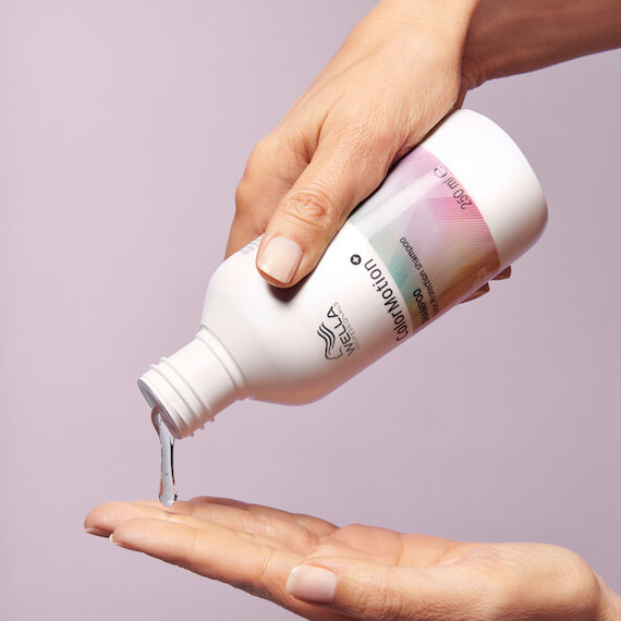 A model pours out shampoo from a bottle of ColorMotion+ Color Protection Shampoo.