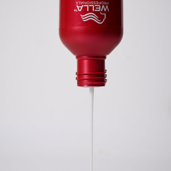 ULTIMATE REPAIR Shampoo is seen upside down with shampoo pouring out.