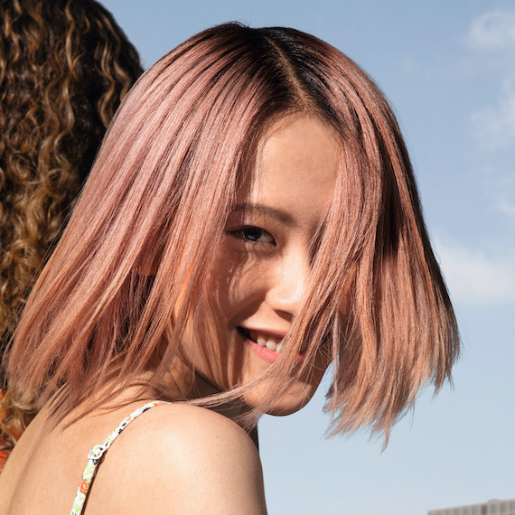 Model mit pastellrosa Bob-Haarschnitt, das der Kamera zugewandt ist.