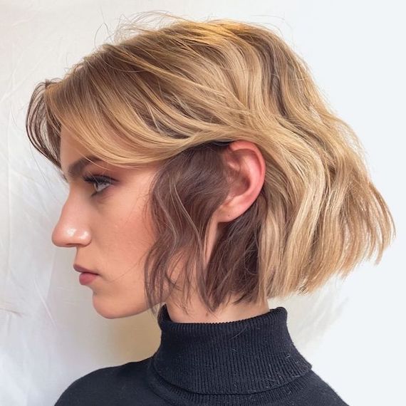 Side profile of model with short, blunt, bob haircut, featuring brown lowlights and blonde highlights.