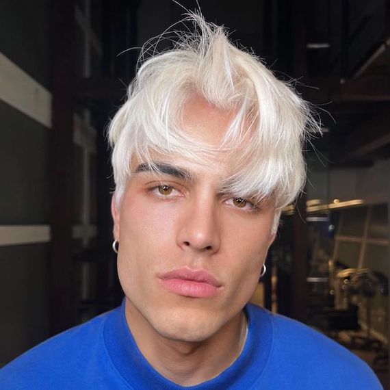 Model with short, Nordic blonde hair styled with curtain bangs