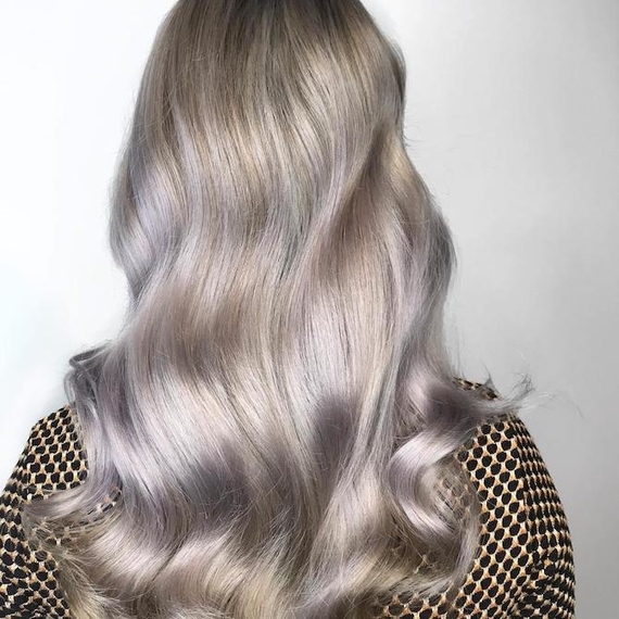 Back of woman’s head with long, wavy, silver balayage hair, created using Wella Professionals.