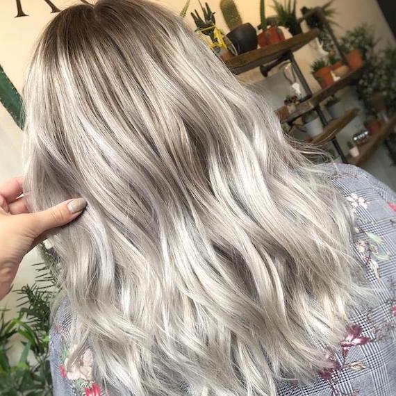 Back of woman’s head with mid-length, tousled, silver balayage hair, created using Wella Professionals.