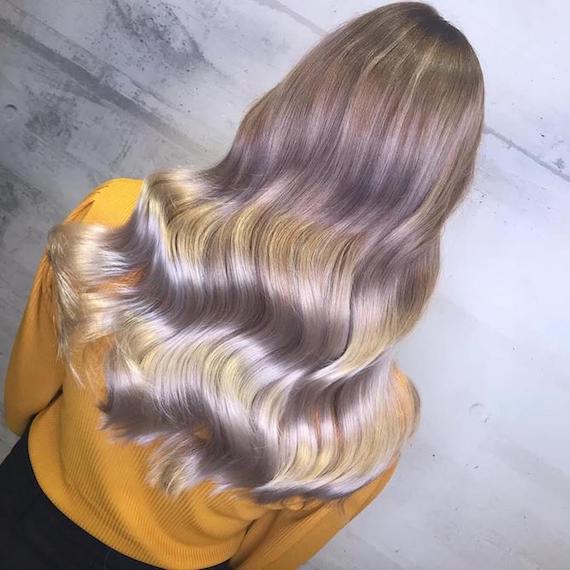 Back of woman’s head with long, wavy, pale balayage hair, created using Wella Professionals.