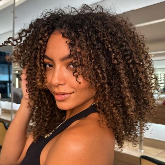 Model with dark brown, beautifully defined curls.