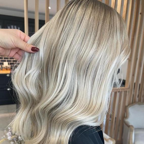 Side profile of woman with long, smooth, vanilla stone blonde hair.