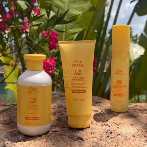 INVIGO Sun Care Shampoo, Conditioner and Spray on a rock with tropical leaves in the background.