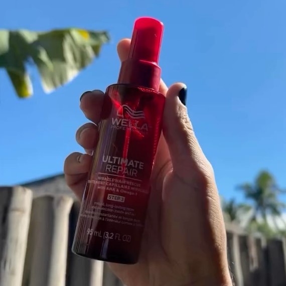 ULTIMATE REPAIR Miracle Hair Rescue held up in front of a blue sky background.