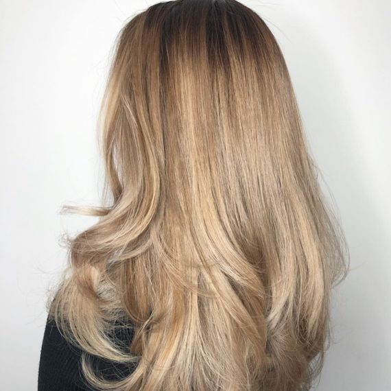 Hinterkopf eines Models mit beige-blondem, glänzendem Haar.