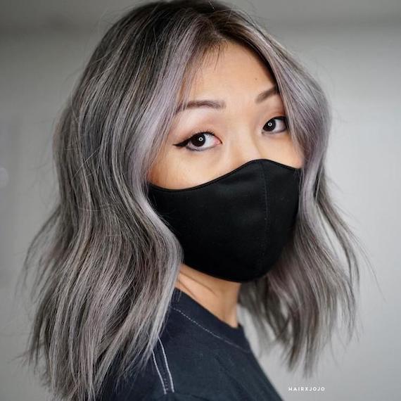 Woman facing the camera with silver gray hair, created using Wella Professionals.