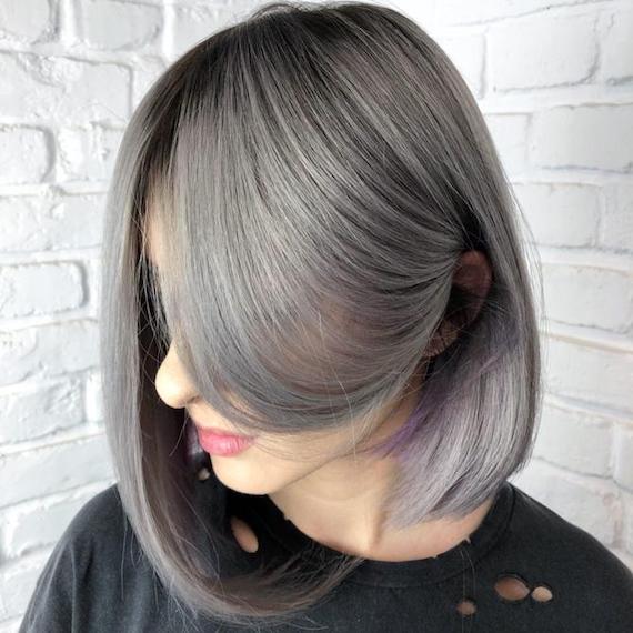 Woman with gray hair tucked behind one ear, created using Wella Professionals.